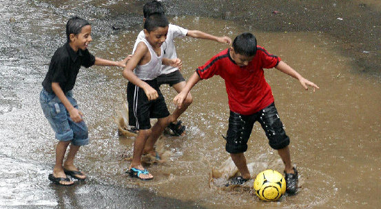 Children Playing Football In Rain